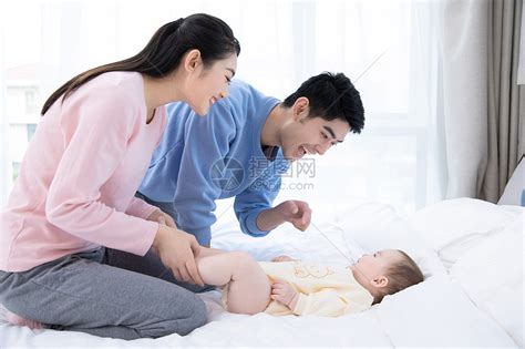 爸爸妈妈带着婴儿在床上玩耍高清图片下载-正版图片501578728-摄图网