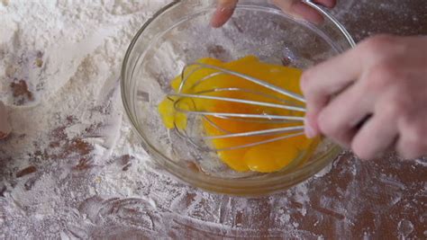 Beating Eggs With Whisk In Glass Bowl, On A Table Full Of Flour, Super ...