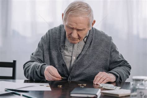 老人坐在桌前在家数钱高清图片下载-正版图片502853354-摄图网