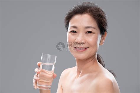 中年女人拿着玻璃杯喝水高清图片下载-正版图片501907340-摄图网