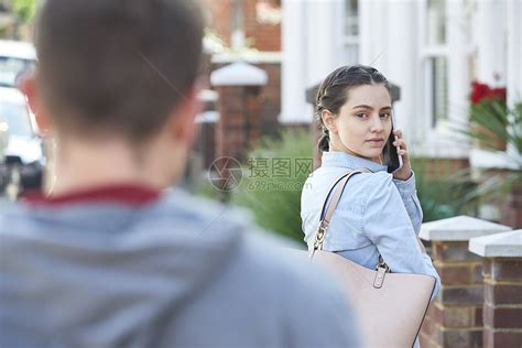 轻女子打电话求救,同时被男人跟踪城市街道上高清图片下载-正版图片300166130-摄图网
