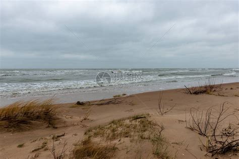女孩在多云的天气里拿着透明的雨伞沿着海边的海滩散步雷暴和大雨下雨高清图片下载-正版图片506471106-摄图网
