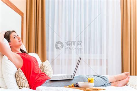 带着笔记本电脑睡在床上的体贴女孩高清图片下载-正版图片303293666-摄图网