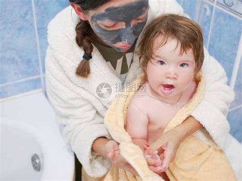 母亲把婴儿放在浴室的毛巾里高清图片下载-正版图片504381675-摄图网