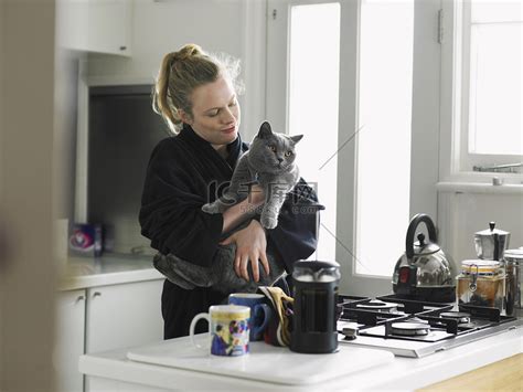 女人抱着猫站在厨房里高清摄影大图-千库网