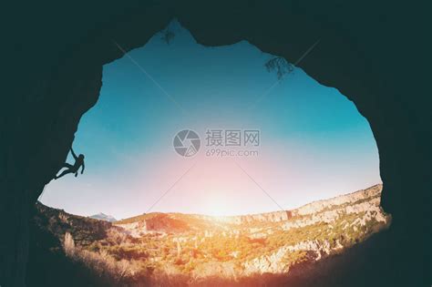 登山者爬上岩石一个女人在日落的背景下克服了一条艰难的攀登路线一位运动员以拱门的形式进行自然降压训练高清图片下载-正版图片505159829-摄图网