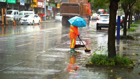 实拍下雨天大雨中扫落叶的环卫工人高清摄影大图-千库网