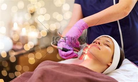 人、美容、美容治疗、美容和技术概念-美容师用微晶换肤术设备对躺在水疗中心的年轻女性进行面部去角质。高清摄影大图-千库网