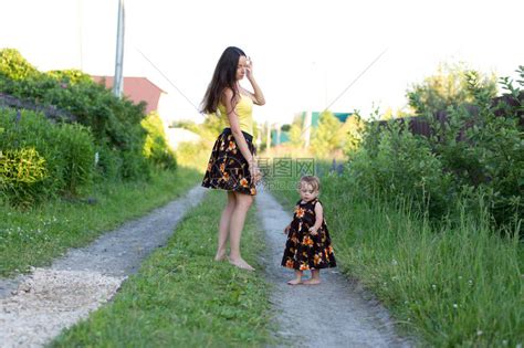 母亲和女婴在乡村公路上赤脚走路穿高清图片下载-正版图片507428649-摄图网
