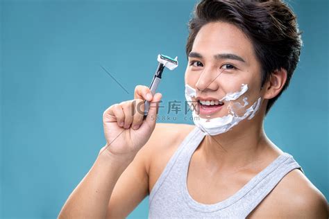 年轻人在洗澡时刮胡子他把剃胡刀递给胡子高清图片下载-正版图片502988291-摄图网