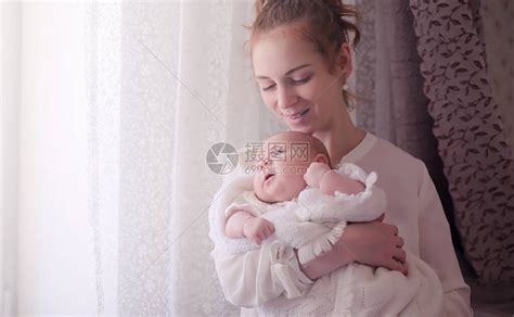 妈怀里抱着一个刚出生的婴儿女孩在窗前抱着一个婴儿母亲高清图片下载-正版图片506237026-摄图网