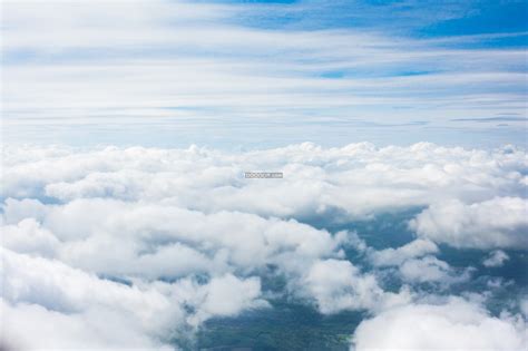 在云层之上俯瞰云海茫茫翻腾飘动云彩之上是广袤无垠的蓝天自然风景素材设计