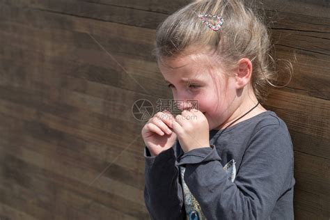 小女孩在木墙边哭高清图片下载-正版图片502667677-摄图网