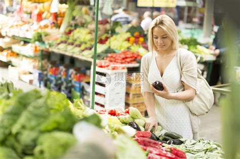 在市场上买蔬菜的年轻妇女在高清图片下载-正版图片503504557-摄图网