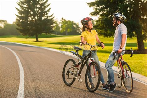 几个学生在户外骑自行车幸福的情侣骑着自行车在路上微笑着看对方完高清图片下载-正版图片503540176-摄图网