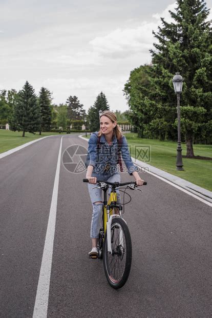 在沥青路上骑自行车的年轻微笑高清图片下载-正版图片503513518-摄图网
