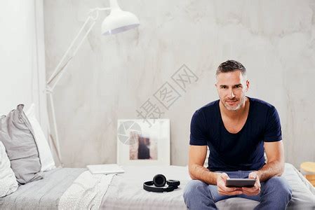 四十多岁的白人男坐在卧室的床上高清图片下载-正版图片505959356-摄图网
