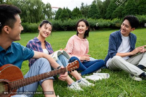 亚裔年轻女在户外家庭花园唱歌时与弹吉他的家伙一起喂饱朋友高清图片下载-正版图片305535023-摄图网