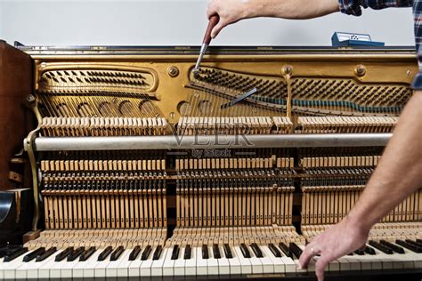 调琴师取下钢琴键盘的特写钢琴调音过程。手和调谐器工具在大钢琴上的特写。调音期间Upright钢琴的详细视图。调音的.图片下载 - 觅知网