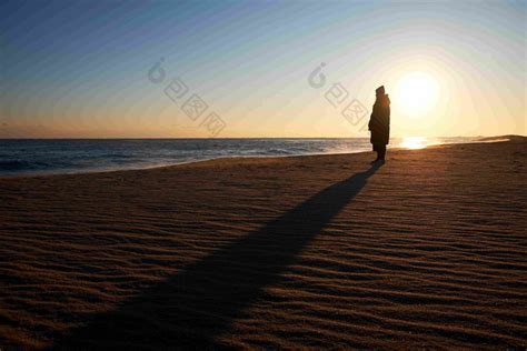 阳光沙滩人影轮廓及拉长的影子图片-包图网