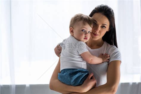 年轻母亲将可爱的婴儿放在家高清图片下载-正版图片503474096-摄图网