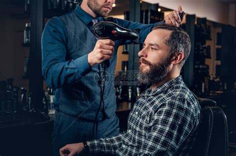 师傅在理发店剪男人的头发和胡须理发师为高清图片下载-正版图片505269421-摄图网