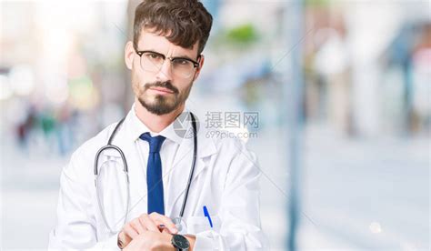 年轻英俊的医生男子穿着医疗大衣露面高清图片下载-正版图片503900112-摄图网