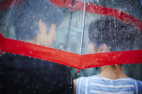下雨天一个女生撑着雨伞走在灯火阑珊的街头