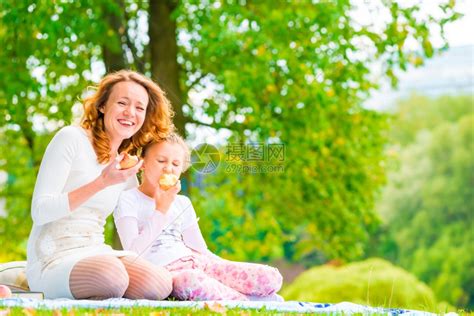 年轻母亲和女儿在公园吃苹果高清图片下载-正版图片303276726-摄图网