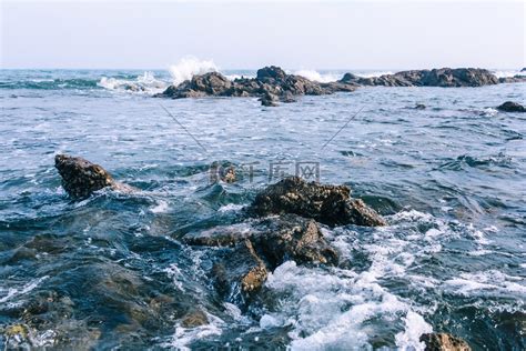 青岛白天海浪沙滩涨潮摄影图配图高清摄影大图-千库网