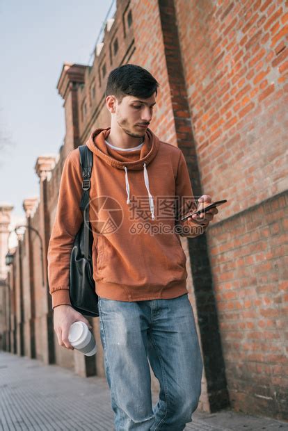 年轻帅哥用手机在街上户外拍摄的肖像高清图片下载-正版图片303606480-摄图网