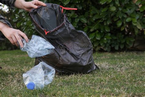 从公园捡塑料瓶的女人环保人士收集塑料垃圾的照片志愿者在户外捡起一高清图片下载-正版图片506426016-摄图网