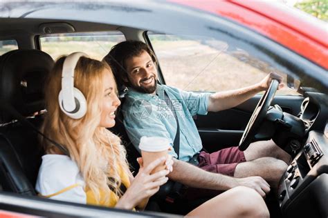 一对夫妇在汽车中旅行女友用耳机听音乐高清图片下载-正版图片502550719-摄图网