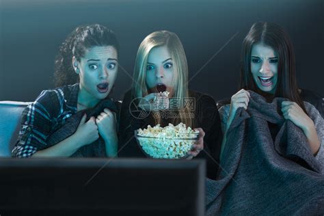 年轻女孩们看恐怖电影吃爆米花高清图片下载-正版图片307831167-摄图网