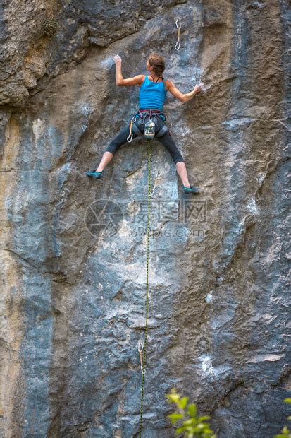 女孩爬上岩石在风景如画的地方训练自然健身一位女士克服了艰难的攀登路线登山者在拱形的自高清图片下载-正版图片505364700-摄图网