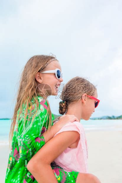 娱乐海岸线假期小女孩在热带海滩玩得开心在浅水区一起玩暑假在海滩的可爱小姐妹两个快乐的小女孩在热带海滩玩得很开心高清图片下载-正版图片 ...