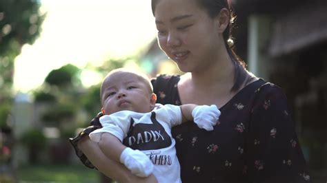 亚洲母亲在后院抱着她的男婴视频素材_ID:VCG42N1339565000-VCG.COM