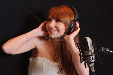 在录音室里对着麦克风唱歌的女孩高清图片下载-正版图片502671357-摄图网
