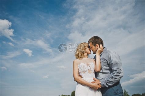 女孩和男人对着天空亲吻穿过3150号田野高清图片下载-正版图片307148869-摄图网