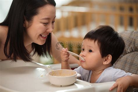年轻妈妈喂宝宝吃饭高清图片下载-正版图片501920044-摄图网