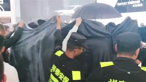 女子坐轮椅闹保时捷展台，工作人员用黑布黑伞遮挡_凤凰网视频_凤凰网