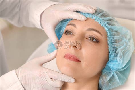 整形外科医生正在诊所对其女病人的面部皮肤高清图片下载-正版图片505764811-摄图网