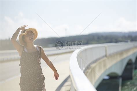 旅途中带着草帽的女性走在海面大桥上大笑高清图片下载-正版图片502054972-摄图网