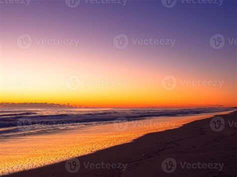 Orange sunrise color on the long beach line 1327751 Stock Photo at Vecteezy