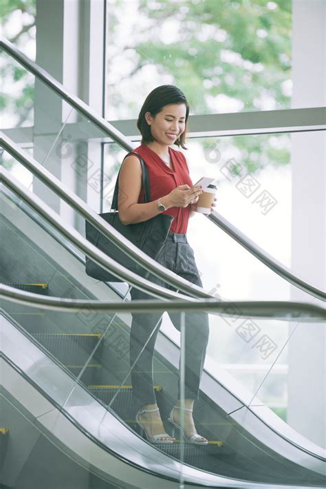 下楼梯玩手机的女人图片-包图网