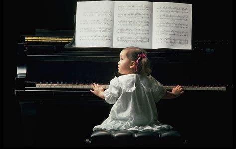 穿着漂亮裙子的女孩坐在钢琴前高清摄影大图-千库网