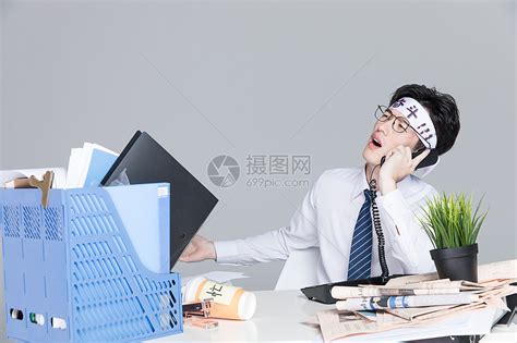 作为一个精疲力尽的工人或雇员在工作中疲惫不堪，作为办公室截止日期或工作狂商人的象征睡在一堆文件中。高清摄影大图-千库网