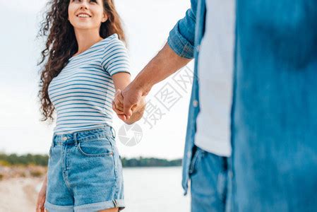 女士旅行欢迎朋友带她的男去海滩女人牵着男的手享受海滩放松恋爱的假日情侣高清图片下载-正版图片307650435-摄图网