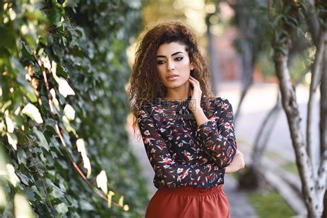 美丽的轻阿拉伯女人,黑色卷发阿拉伯女孩街上穿休闲服高清图片下载-正版图片300142403-摄图网