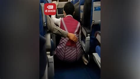 航班遇强气流发生抖动空姐蹲下避险 女乘客伸手在背后默默守护_北京时间